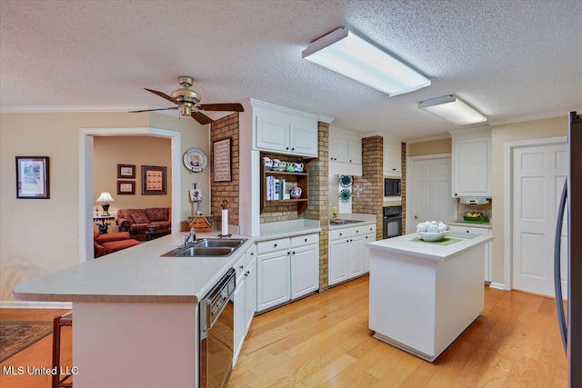 kitchen with white cabinetry, a breakfast bar area, a center island with sink, and black appliances