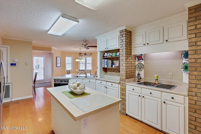 kitchen with white cabinetry, hanging light fixtures, kitchen peninsula, a kitchen island, and black appliances