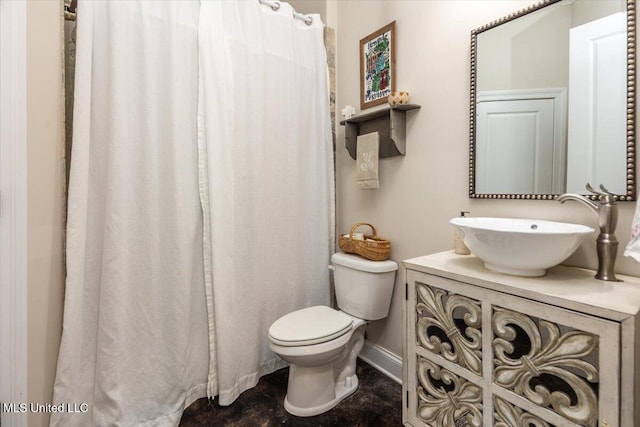 bathroom featuring vanity, baseboards, and toilet