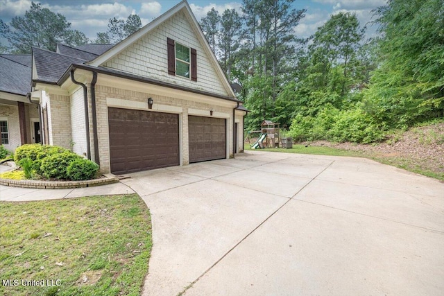 view of side of home featuring roof with shingles, driveway, and brick siding
