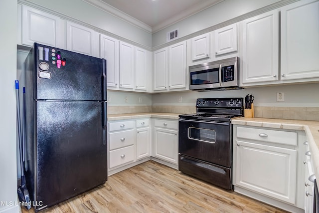 kitchen with ornamental molding, black appliances, light hardwood / wood-style flooring, and white cabinets