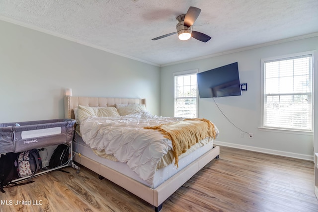 bedroom with ceiling fan, hardwood / wood-style flooring, and multiple windows