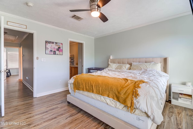 bedroom featuring ornamental molding, a textured ceiling, wood-type flooring, and ceiling fan