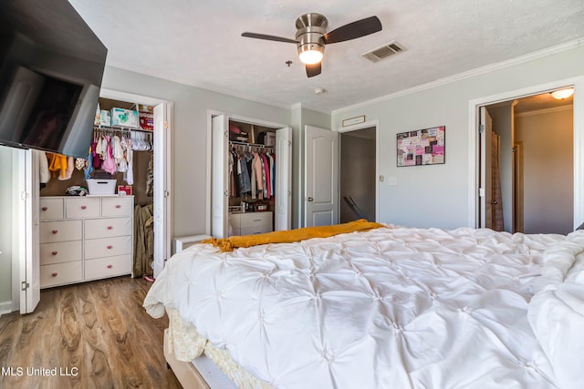 bedroom featuring ceiling fan, crown molding, a textured ceiling, and hardwood / wood-style floors