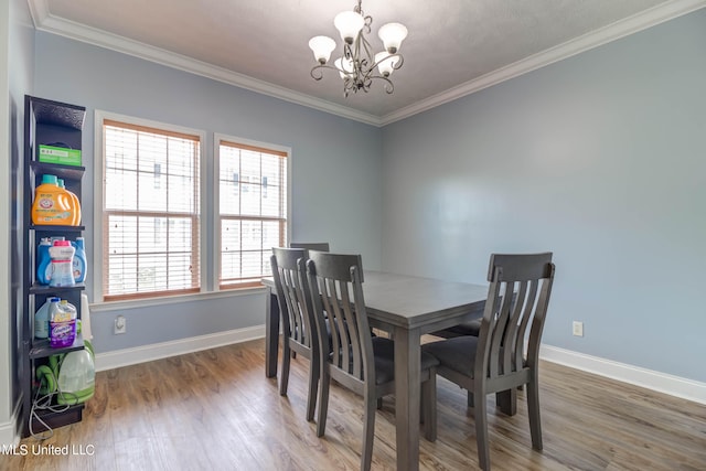 dining space with crown molding, a notable chandelier, and wood-type flooring