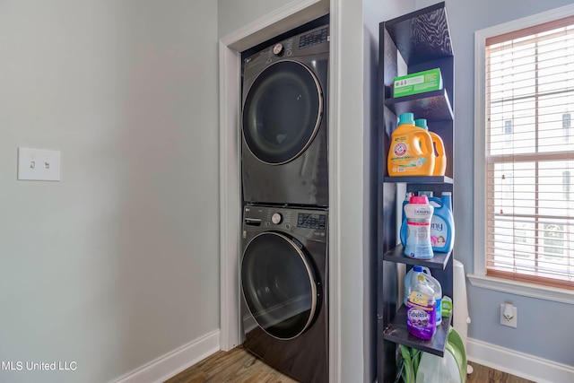 washroom with stacked washer and dryer and hardwood / wood-style floors