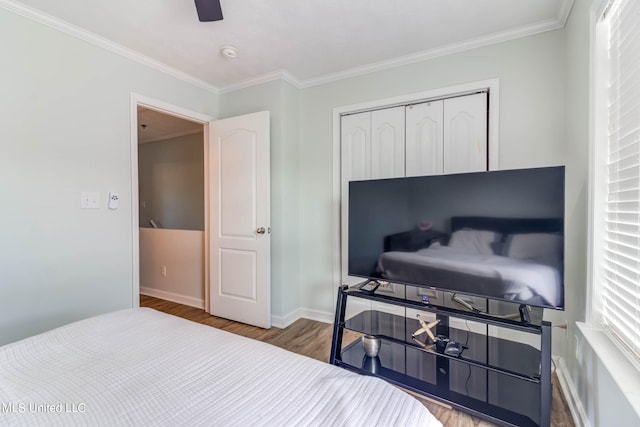 bedroom with a closet, ceiling fan, ornamental molding, and hardwood / wood-style floors