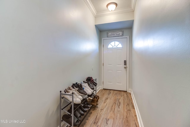 entryway with light hardwood / wood-style floors and crown molding