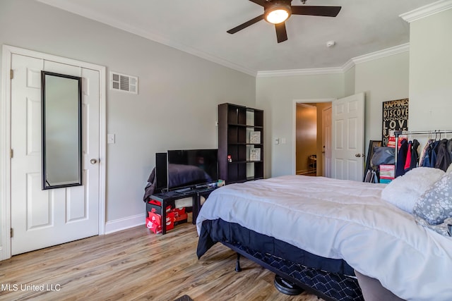 bedroom with crown molding, light hardwood / wood-style floors, and ceiling fan