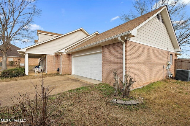 view of side of home featuring driveway, an attached garage, fence, central AC, and brick siding