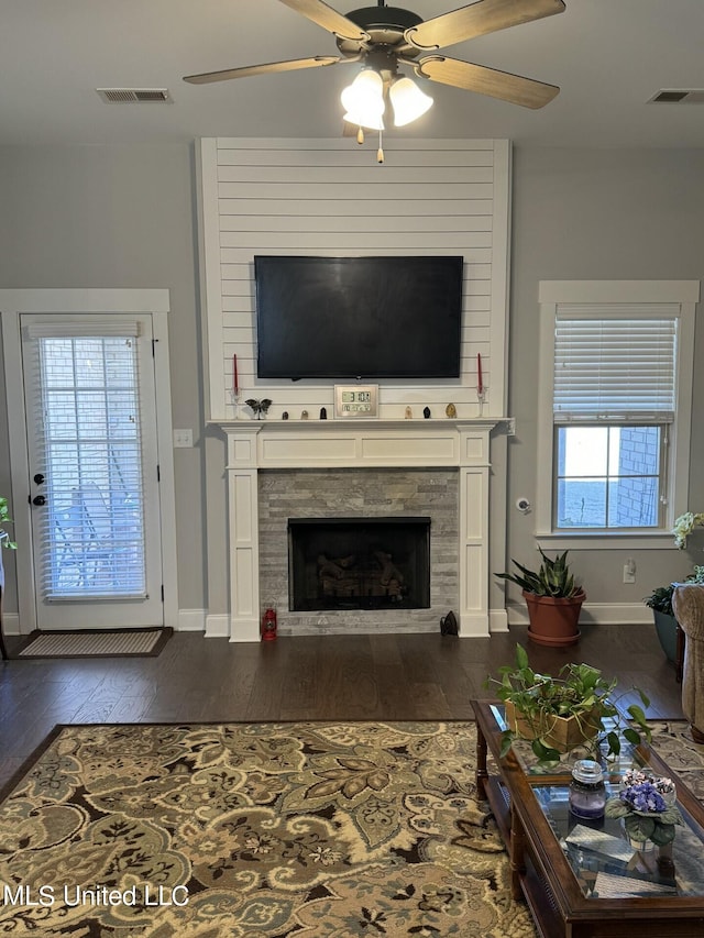 living room featuring ceiling fan, plenty of natural light, and dark hardwood / wood-style floors