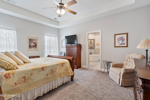 bedroom with ensuite bath, light colored carpet, and ceiling fan