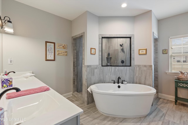 bathroom with vanity, tile walls, wood-type flooring, and shower with separate bathtub