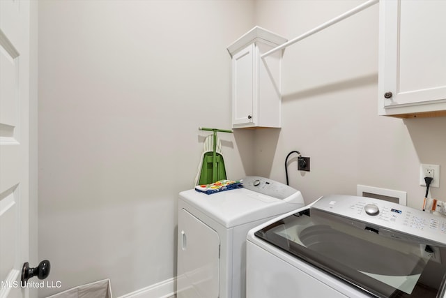 washroom featuring separate washer and dryer and cabinets