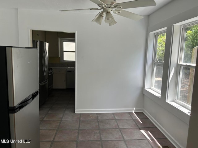 interior space with dark tile patterned floors and ceiling fan