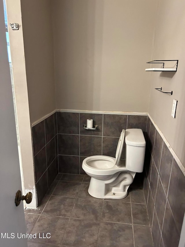 bathroom featuring tile walls, toilet, and tile patterned floors