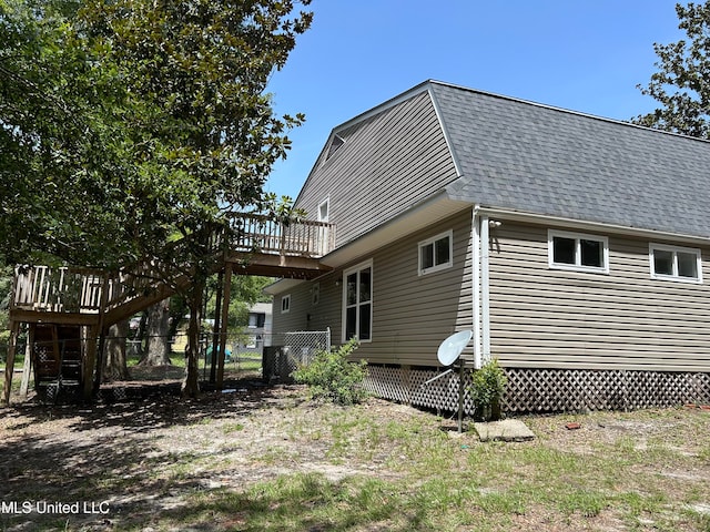 rear view of property featuring a wooden deck