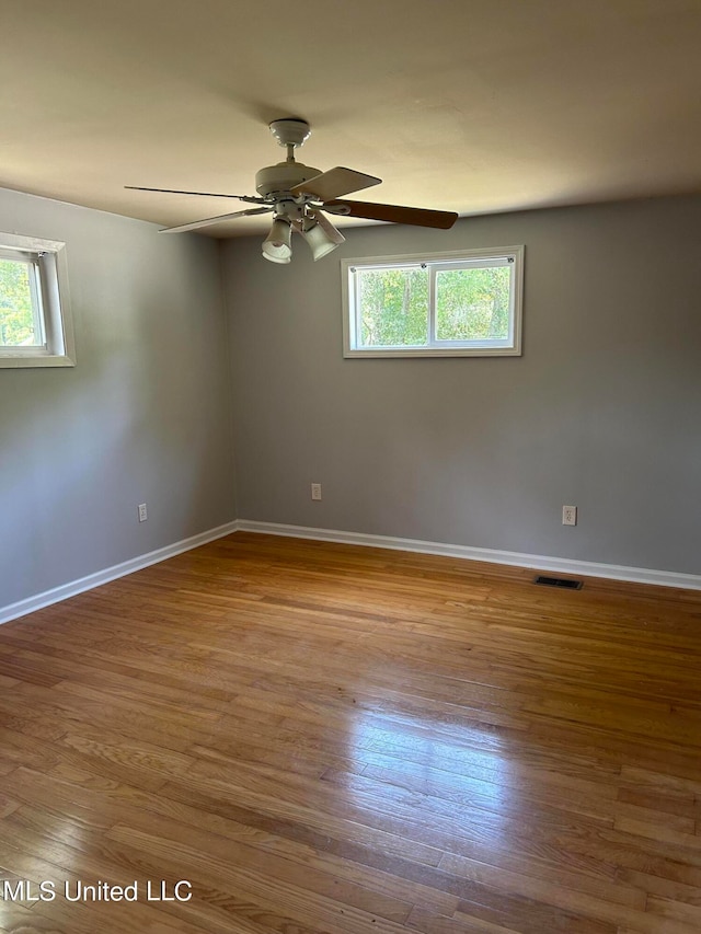 spare room featuring hardwood / wood-style floors, plenty of natural light, and ceiling fan