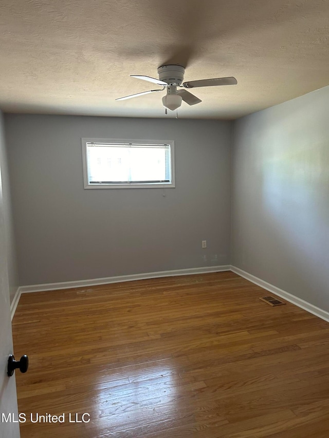 spare room featuring hardwood / wood-style floors, a textured ceiling, and ceiling fan