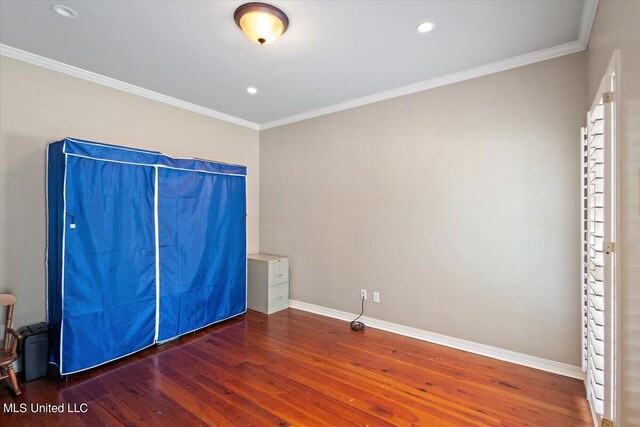 unfurnished bedroom with ornamental molding and dark hardwood / wood-style floors