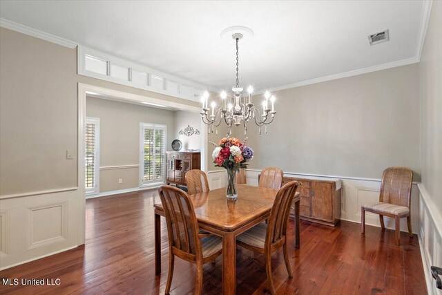 dining room featuring a notable chandelier, ornamental molding, and dark hardwood / wood-style flooring