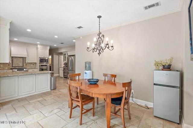 dining room featuring a notable chandelier, ornamental molding, and sink