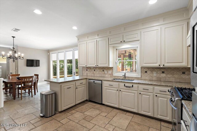 kitchen with backsplash, appliances with stainless steel finishes, and a healthy amount of sunlight