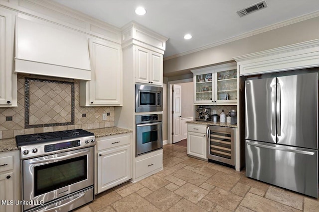 kitchen with appliances with stainless steel finishes, decorative backsplash, and wine cooler