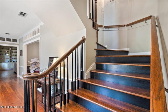 stairway featuring hardwood / wood-style flooring and built in features