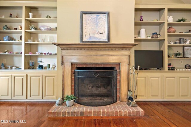 living room with dark wood-type flooring and a brick fireplace