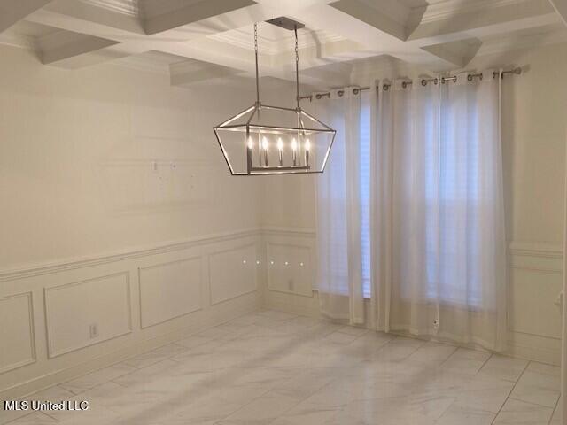 unfurnished dining area featuring coffered ceiling, ornamental molding, and beamed ceiling