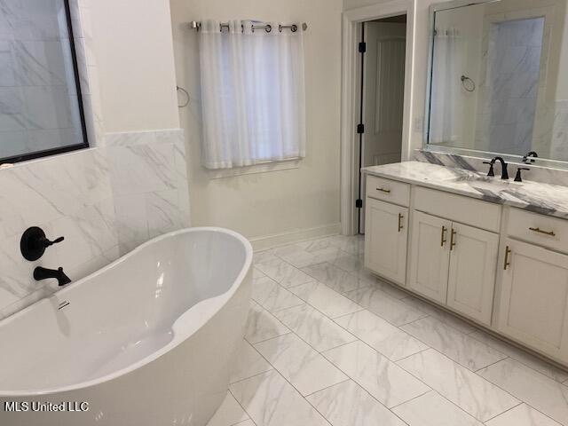 bathroom featuring independent shower and bath, vanity, and tile walls