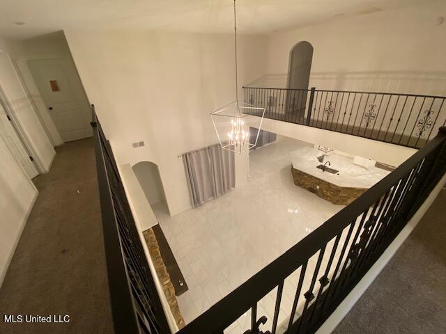 staircase featuring carpet and a notable chandelier