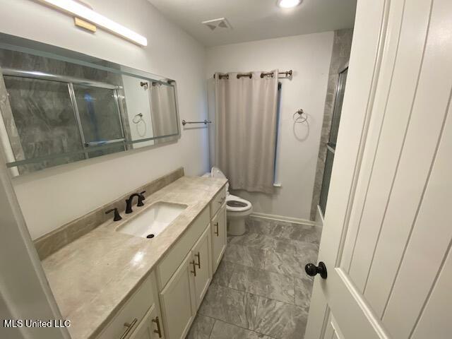 bathroom with walk in shower, vanity, and toilet