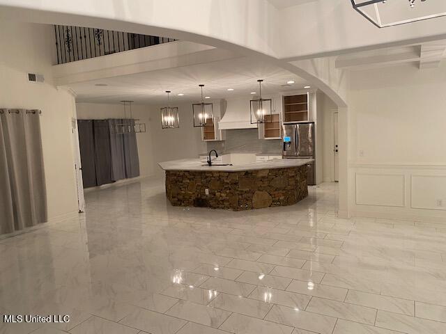 bathroom featuring sink, a high ceiling, and backsplash