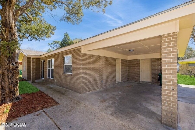 exterior space featuring brick siding and an attached carport