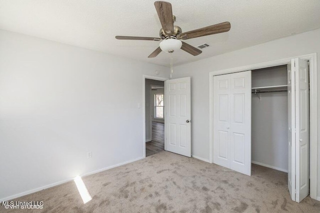 unfurnished bedroom with visible vents, baseboards, a closet, and carpet flooring