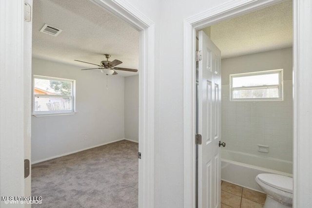 full bath with a wealth of natural light, visible vents, a textured ceiling, and ceiling fan