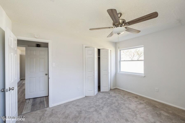 unfurnished bedroom featuring a closet, baseboards, a textured ceiling, and carpet