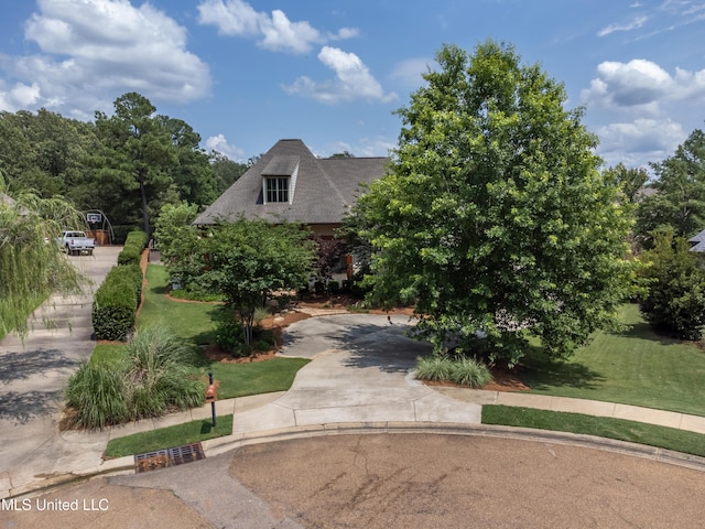 view of front of property with a front yard and concrete driveway