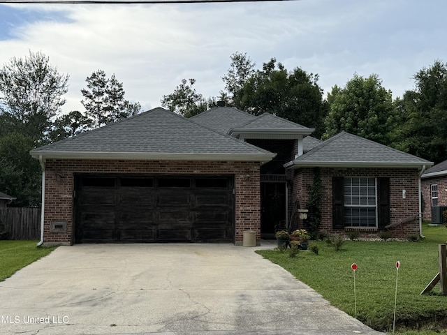 9958 Kahana St, Diamondhead, MS 39525 - view of front facade with a garage, concrete driveway, brick siding, a front yard, and roof with shingles