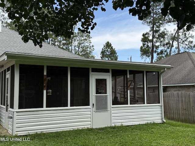 9958 Kahana St, Diamondhead, MS 39525 - rear view of property with a shingled roof and a sunroom