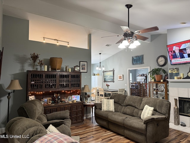 9958 Kahana St, Diamondhead, MS 39525 - living area with wood finished floors, ceiling fan, a chandelier, a tiled fireplace, and track lighting