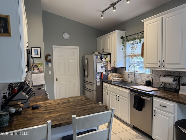 9958 Kahana St, Diamondhead, MS 39525 - kitchen with stainless steel appliances, butcher block counters, backsplash, white cabinets, and lofted ceiling
