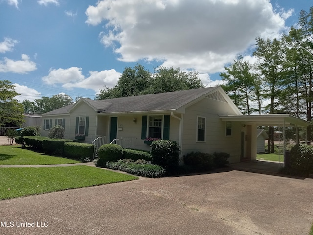 207 W Percy St, Indianola, MS 38751 - ranch-style home with concrete driveway, a front yard, an attached carport, a porch, and a shingled roof