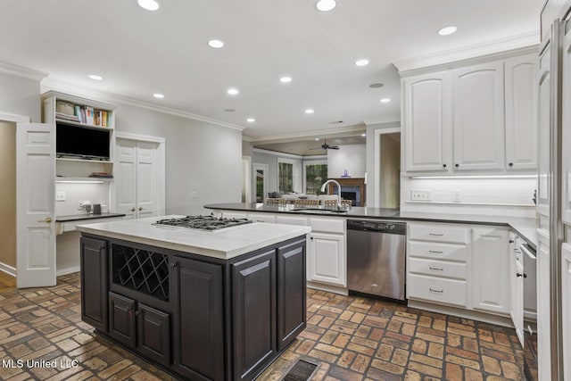 435 Glenway Dr, Jackson, MS 39216 - kitchen with a sink, white cabinets, a peninsula, brick floor, and stainless steel appliances