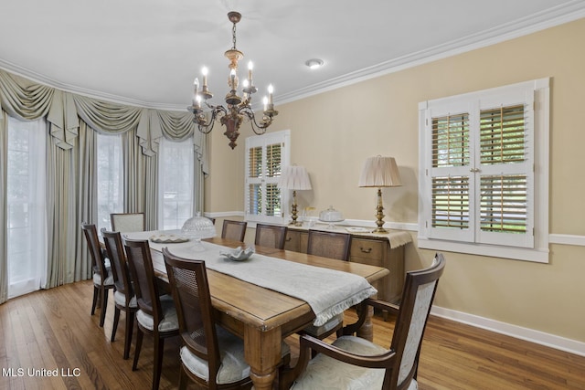 435 Glenway Dr, Jackson, MS 39216 - dining space featuring crown molding, a notable chandelier, a healthy amount of sunlight, and wood finished floors