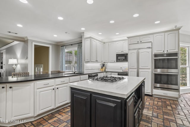435 Glenway Dr, Jackson, MS 39216 - kitchen featuring visible vents, ornamental molding, built in appliances, and brick floor
