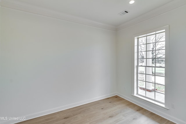 unfurnished room featuring a healthy amount of sunlight, light wood-type flooring, and crown molding