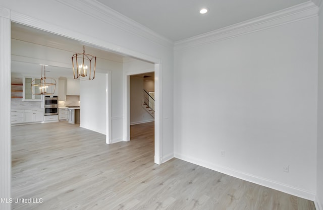 interior space featuring ornamental molding, light wood-type flooring, and a chandelier